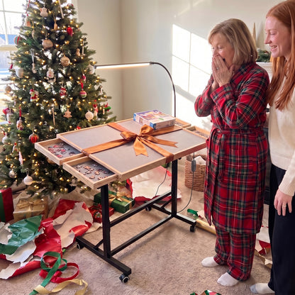 Mom surprised on Christmas morning with a Couchside puzzle table and a bow